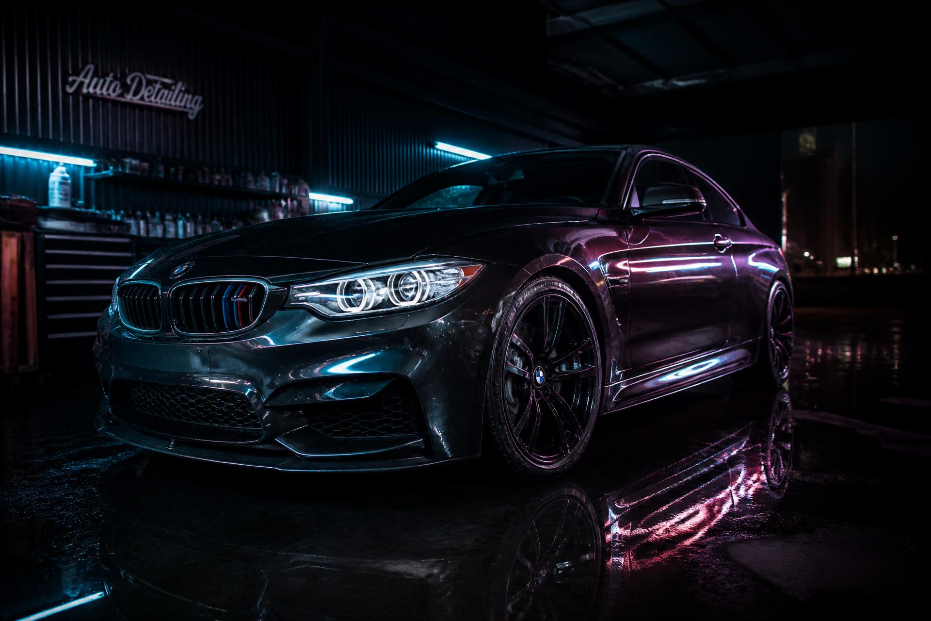 Dark car freshly detailed under workshop lighting in Mareeba
